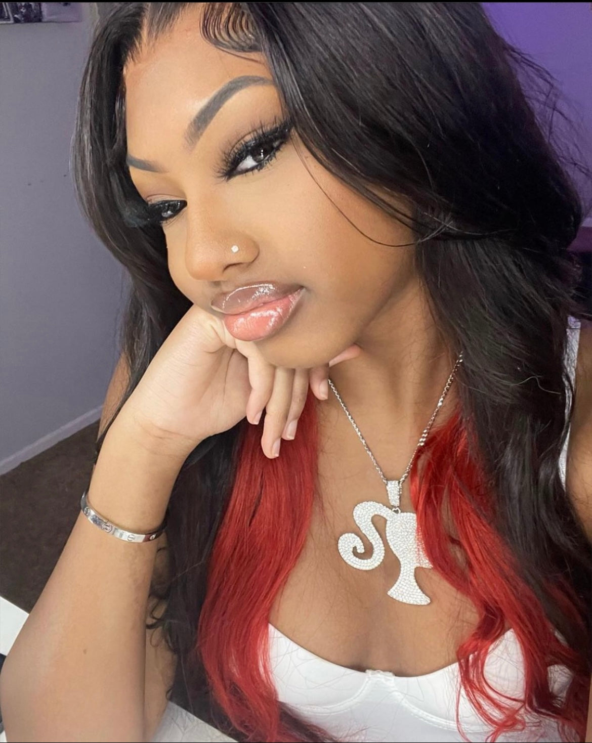 Image of model wearing silver iced out doll pendant.